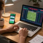 Person engaging with 1gom sports betting app on laptop, displaying live betting odds in cozy home setting.