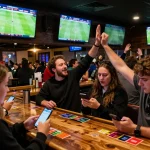 Cakhia TV sports betting atmosphere with fans cheering for soccer and checking odds on mobile devices