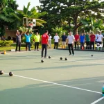 Exciting petanque match at fopikotatarakan.org with players, cheering fans, and lush green setting.